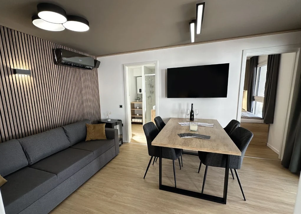 Durchdachter Wohn- und Essbereich mit Sofa, Tisch und warmen Holzoberflächen
